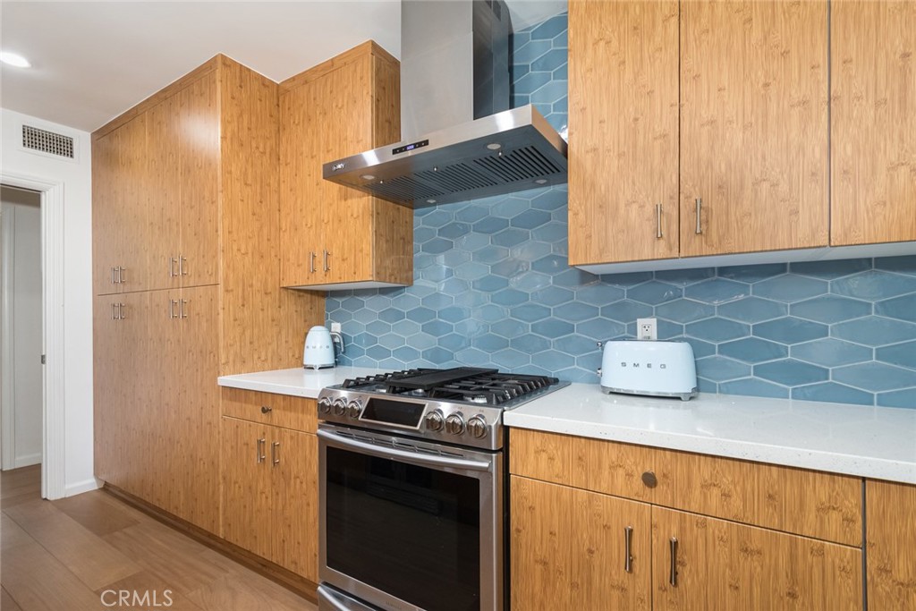 3611 El Lado Drive Glendale, CA 91208 - Photo 12 of 31 a kitchen with stainless steel appliances wooden cabinets and a stove top oven