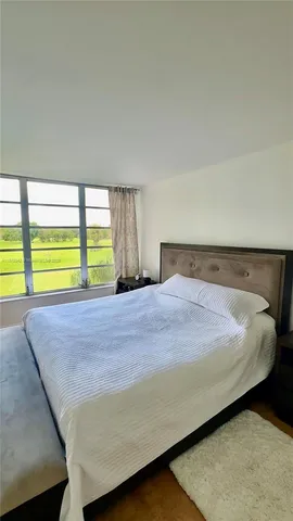 a bedroom with a bed and a floor to ceiling window