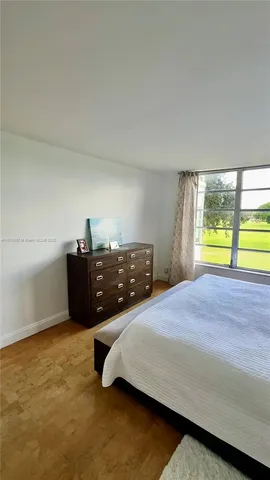 a bedroom with a bed and two large window