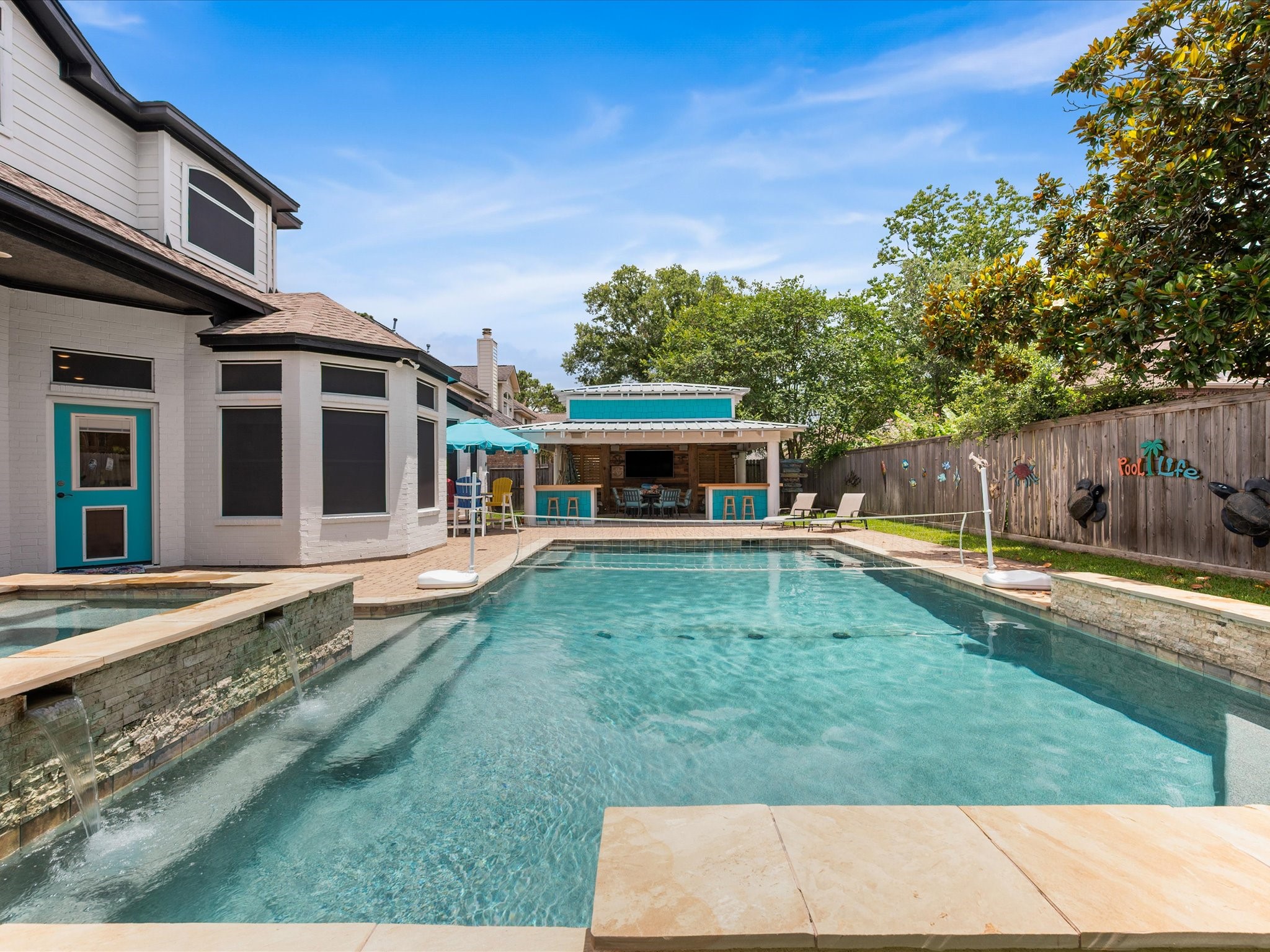 5910 Center Ct Drive Spring, TX 77379 - Photo 37 of 50 The retreat-like pool, added in 2015, has been enhanced with a new pump (2026) and pool heater (2025), ensuring comfort and functionality for year-round enjoyment. The waterfall features create a tranquil space for basking in the summer sun.