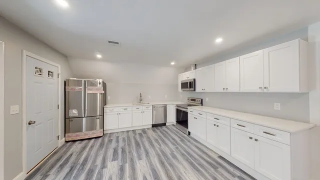 a kitchen with white cabinets and stainless steel appliances