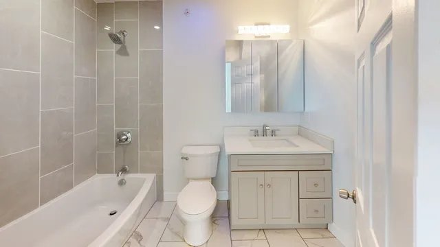 a bathroom with a granite countertop sink toilet and shower