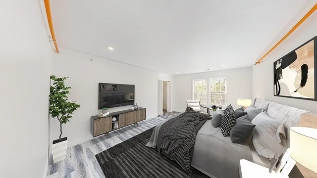 a living room with furniture a flat screen tv and a potted plant
