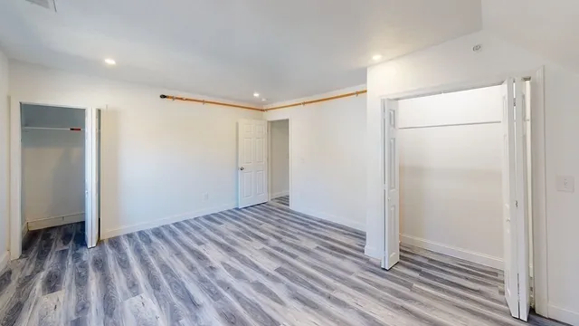 a view of an empty room with wooden floor