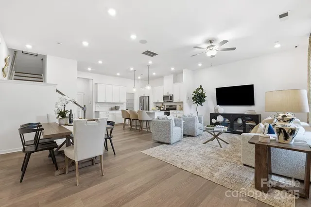 a living room with furniture kitchen view and a flat screen tv
