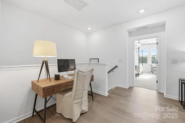 a view of a workspace with furniture and wooden floor