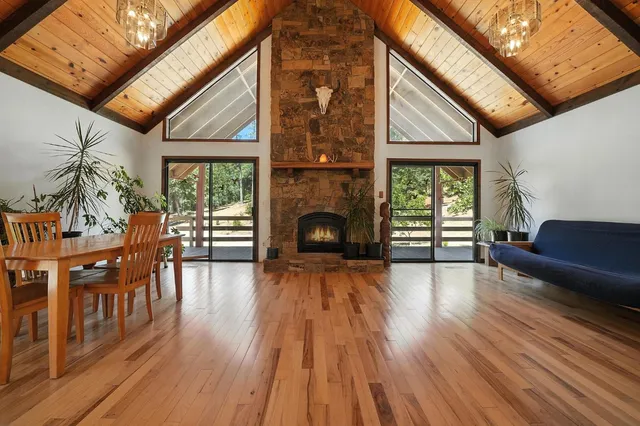 a kitchen with a refrigerator a stove top oven a sink and a dining table with wooden floor