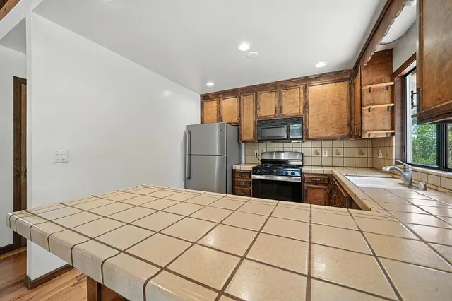 a view of a patio with table and chairs with wooden floor and fence