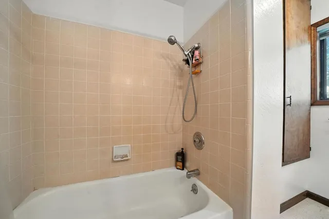 a spacious bedroom with a bed and a chandelier