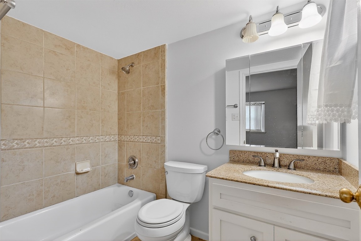 11807 South Ridgewood Circle Houston, TX 77071 - Photo 10 of 18 a bathroom with a granite countertop sink a toilet and shower