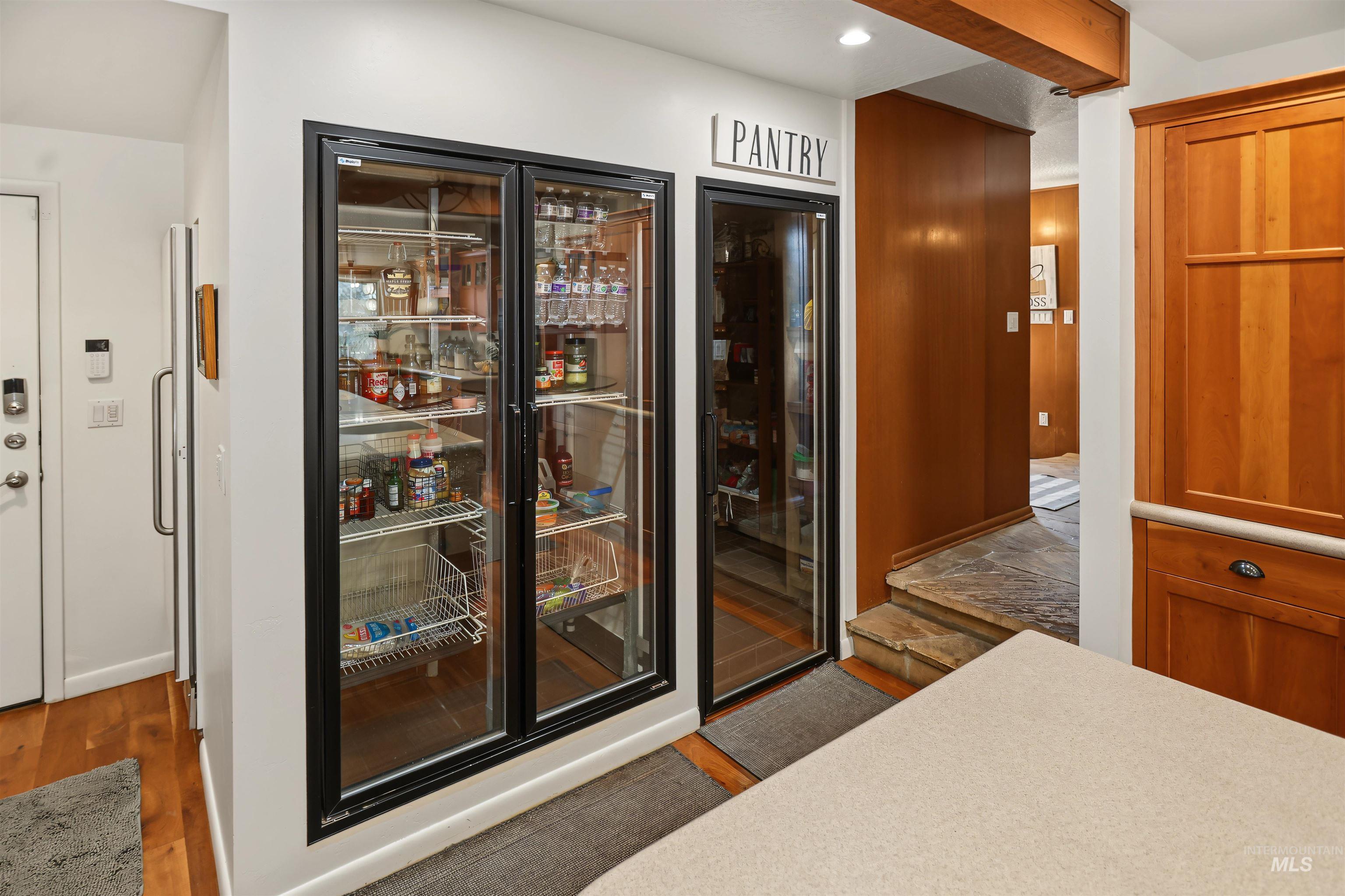 508 East Elm Avenue Parma, ID 83660 - Photo 13 of 50 Dual glass-front beverage refrigerators, designated pantry area, natural wood cabinetry, and a wood-beamed ceiling detail