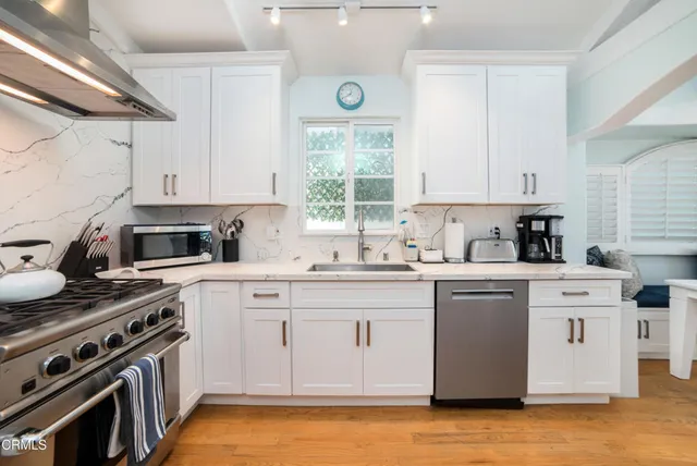 a kitchen with a stove a sink and a window