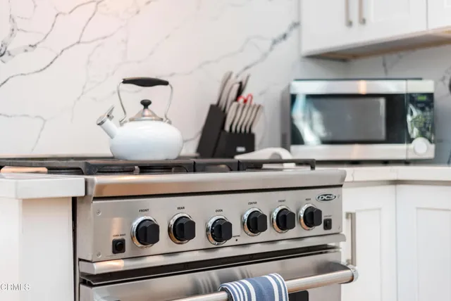 a close view of kitchen sink with stove and microwave