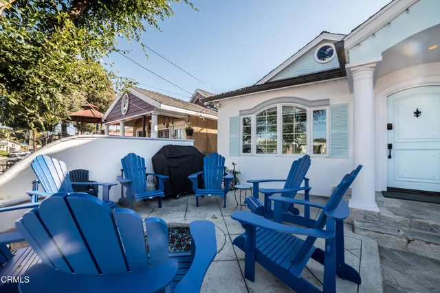 a view of a house with a chairs and table in a patio