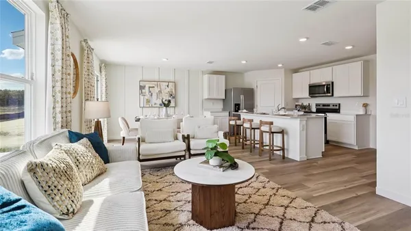 a living room with furniture and a dining table with kitchen view