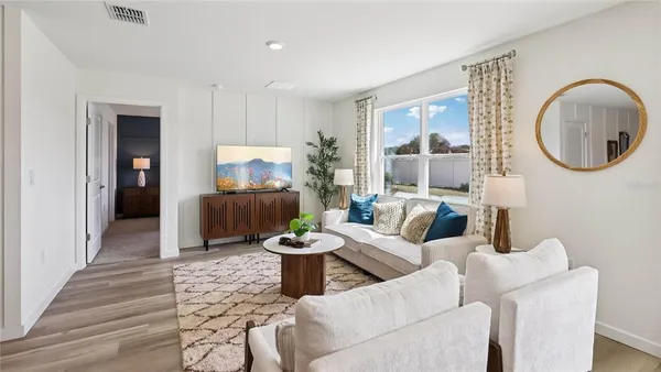a living room with furniture a mirror and a potted plant