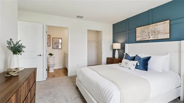 a bedroom with a bed and a potted plant