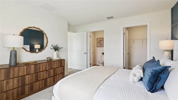 a bedroom with a large bed and a mirror