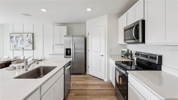a kitchen with stainless steel appliances a sink stove and refrigerator