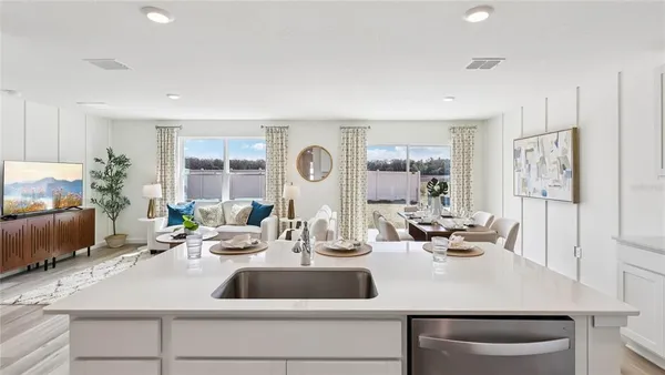 a kitchen with a sink a counter top space and living room area