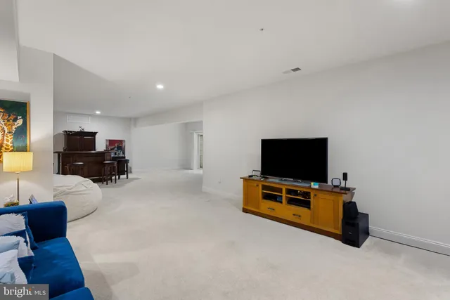 a view of a backyard with table and chairs under an umbrella with large trees