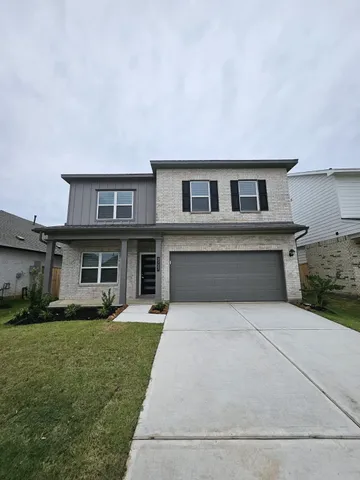 a front view of a house with a yard and trees