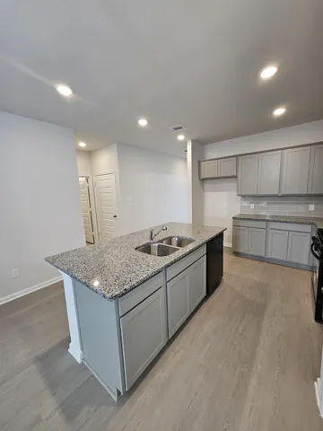 a large kitchen with stainless steel appliances granite countertop a stove and a sink