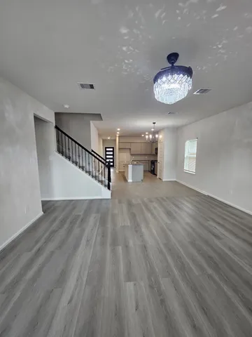 a view of a livingroom with a hall and wooden floor