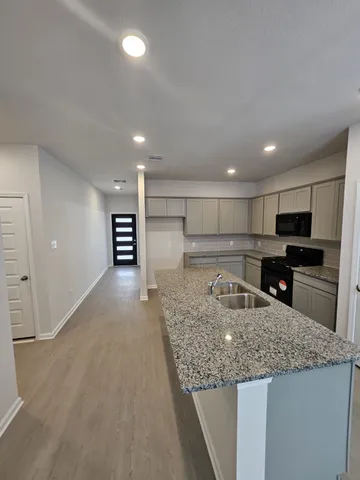 a kitchen with stainless steel appliances granite countertop a sink and a refrigerator