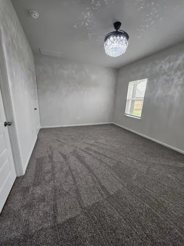 an empty room with windows and ceiling fan