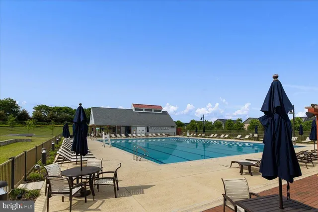 a view of a lake with couches and table and chairs in patio