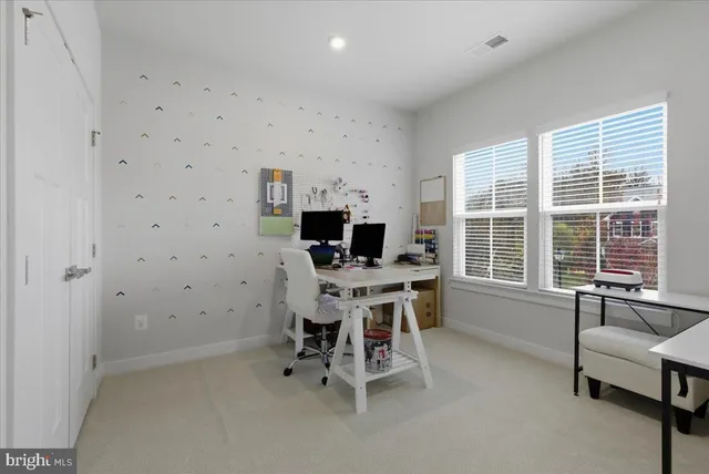 a view of a workspace with furniture and a window