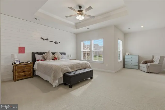 a spacious bedroom with a bed and a chandelier