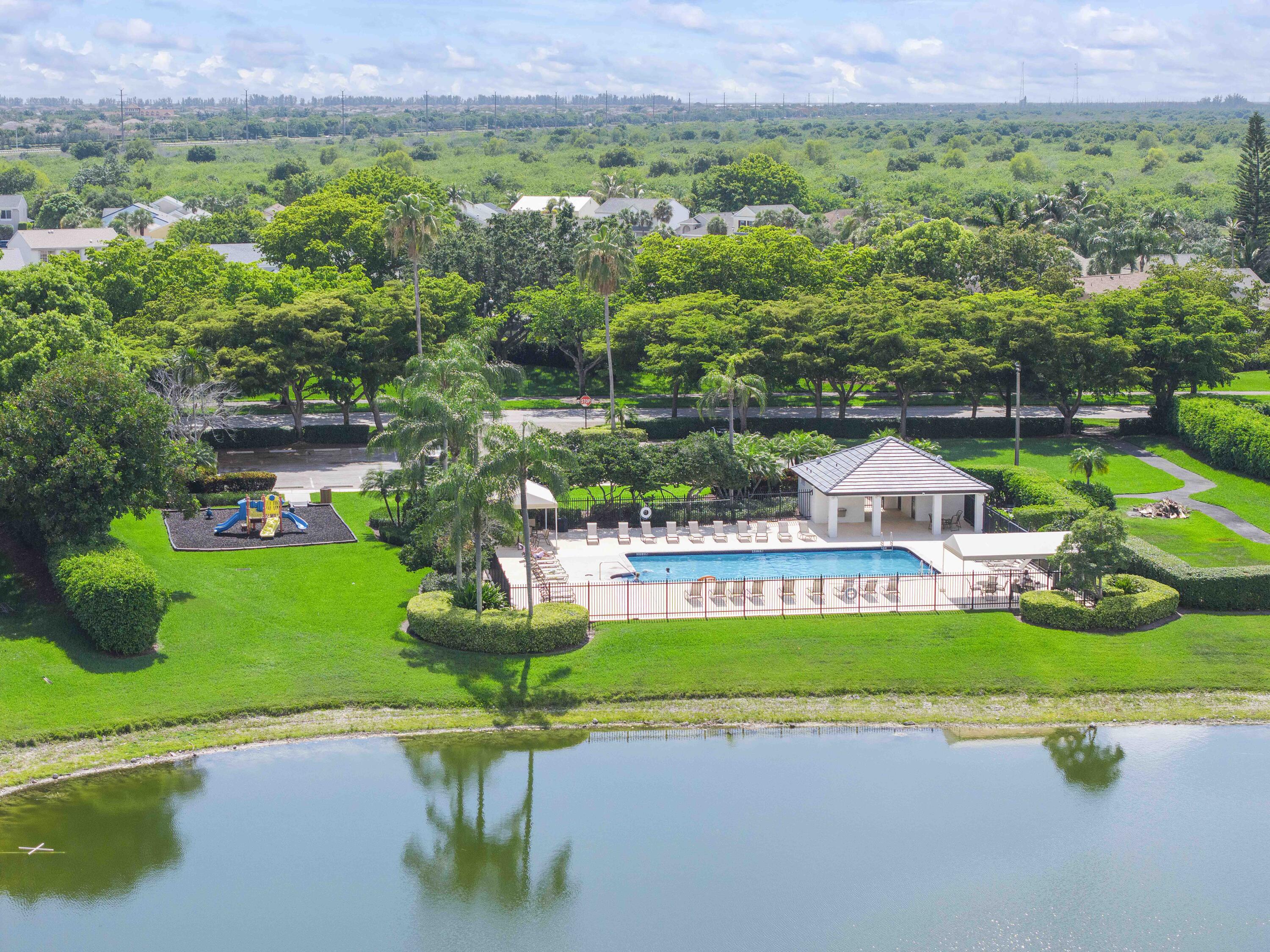 12328 St Simon Drive Boca Raton, FL 33428 - Photo 49 of 52 a front view of a house with a garden and a yard