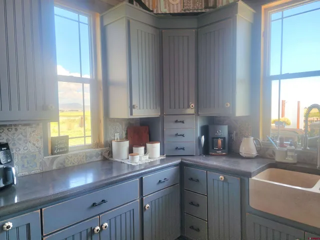 a kitchen with stainless steel appliances granite countertop a sink a window and cabinets