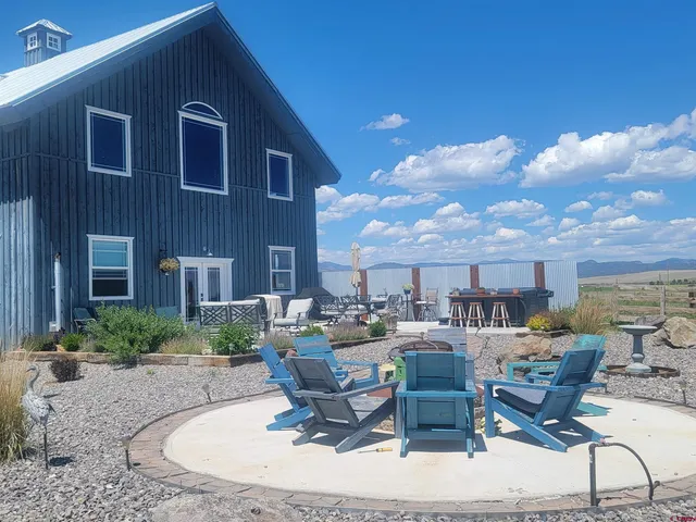 a view of a patio with dining table and chairs with potted plants