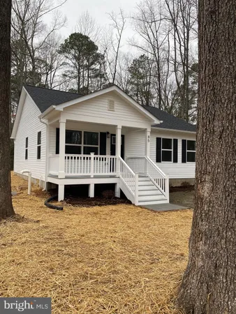 a white house that has a tree in front of it