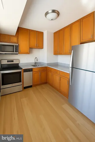 a kitchen with stainless steel appliances granite countertop a refrigerator a stove top oven a sink and dishwasher