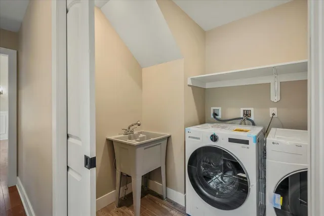 a view of an empty room with wooden floor fireplace and a window