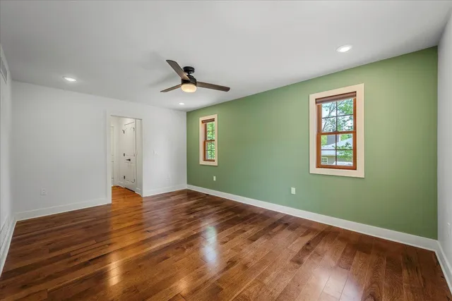 a kitchen with stainless steel appliances granite countertop a stove top oven a sink dishwasher and white cabinets with wooden floor