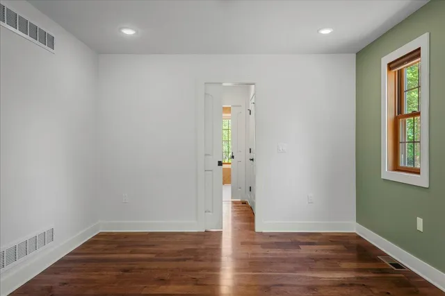 a kitchen with stainless steel appliances granite countertop a stove top oven a sink dishwasher a dining table and chairs with wooden floor