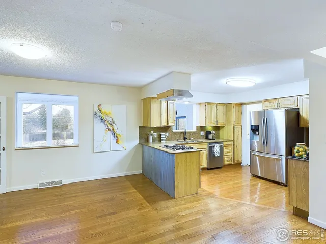 a view of a kitchen with kitchen island a counter top space a sink stainless steel appliances and cabinets