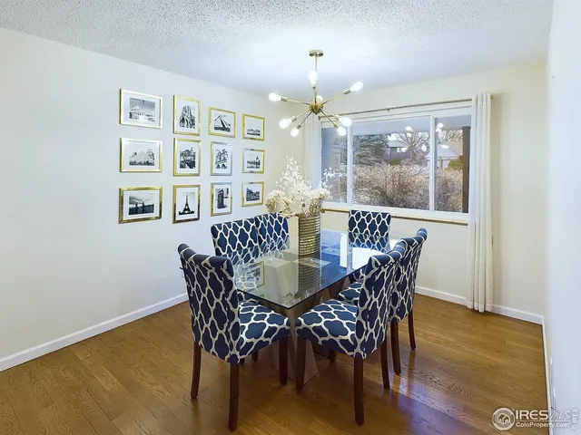 a dining room with furniture a chandelier and wooden floor