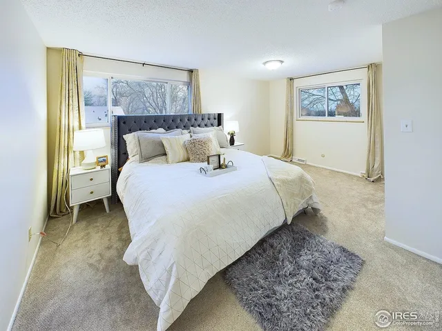 a bed sitting in a bedroom next to a window