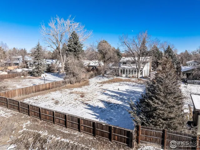 a view of a backyard with wooden fence