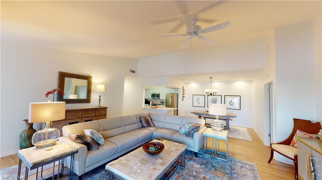 792 Willowbrook Drive, Unit 408 Naples, FL 34108 - Photo 2 of 7 a living room with furniture and a lamp