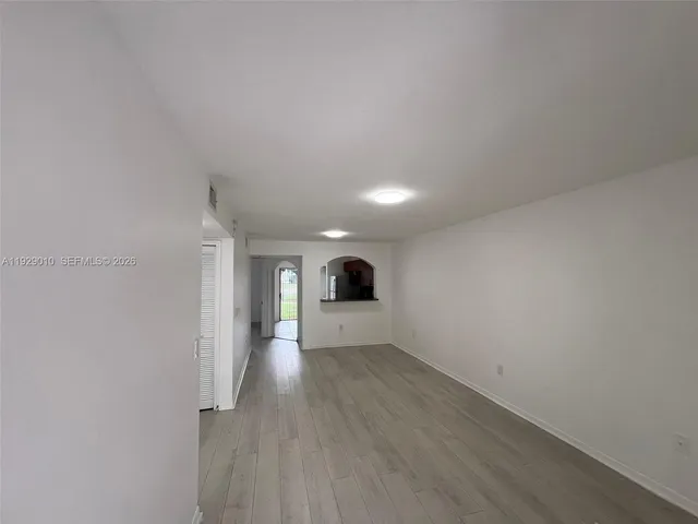 a view of a big room with wooden floor and windows