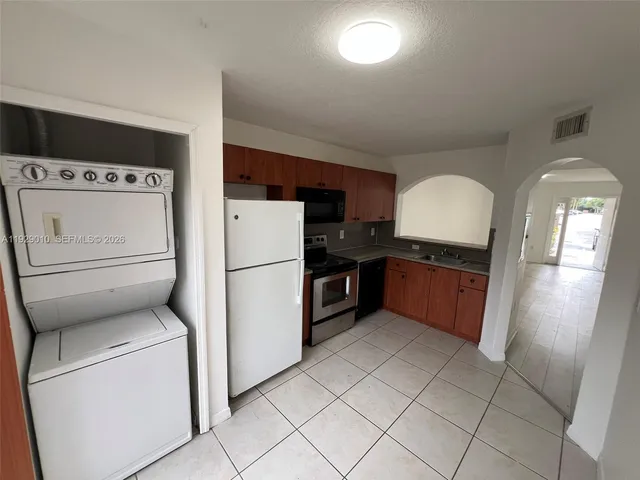 a kitchen with a refrigerator sink and cabinets