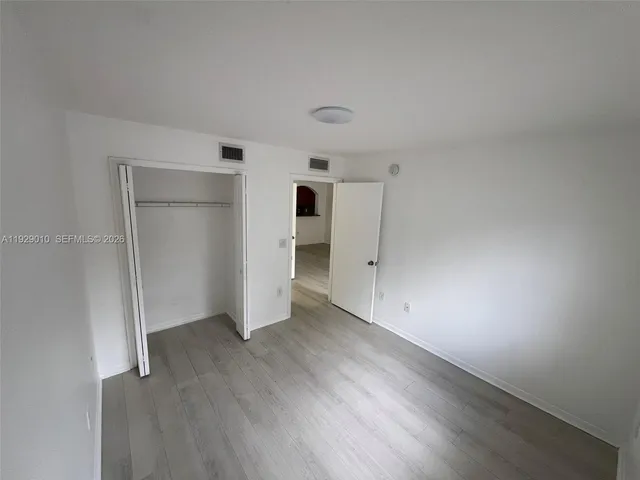 an empty room with closet and wooden floor