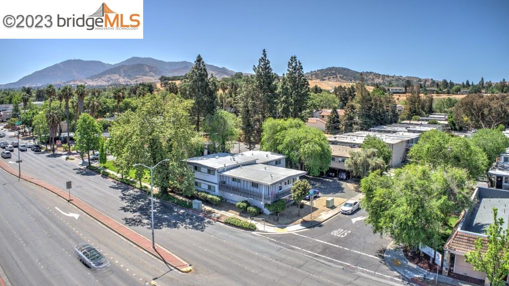 a view of a house with a yard and mountain view in front of it